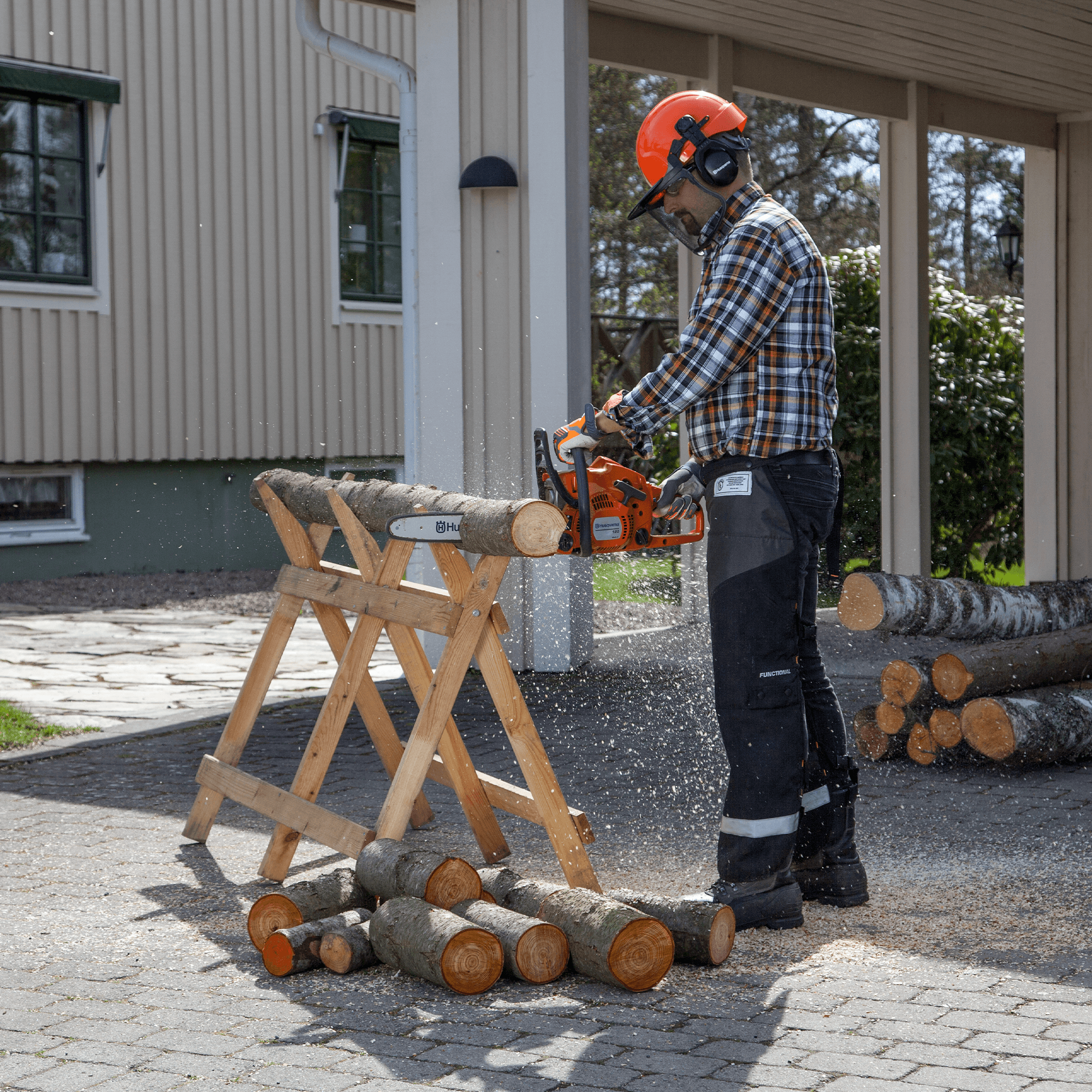 man holding chainsaw whilst cutting tree